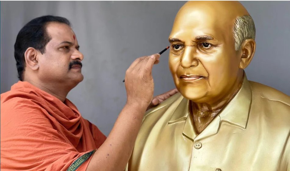 Sculptor Rajkumar Vudayar painting the eye of a golden bust
